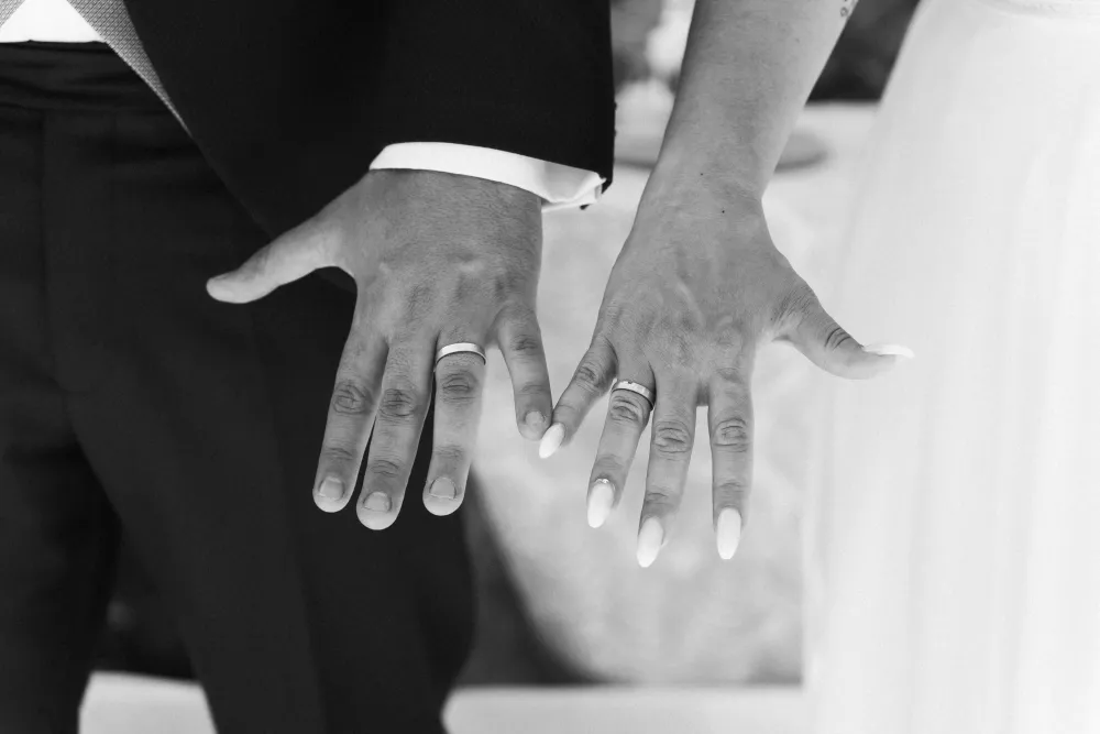 Las manos de los novios con las alianzas, en blanco y negro